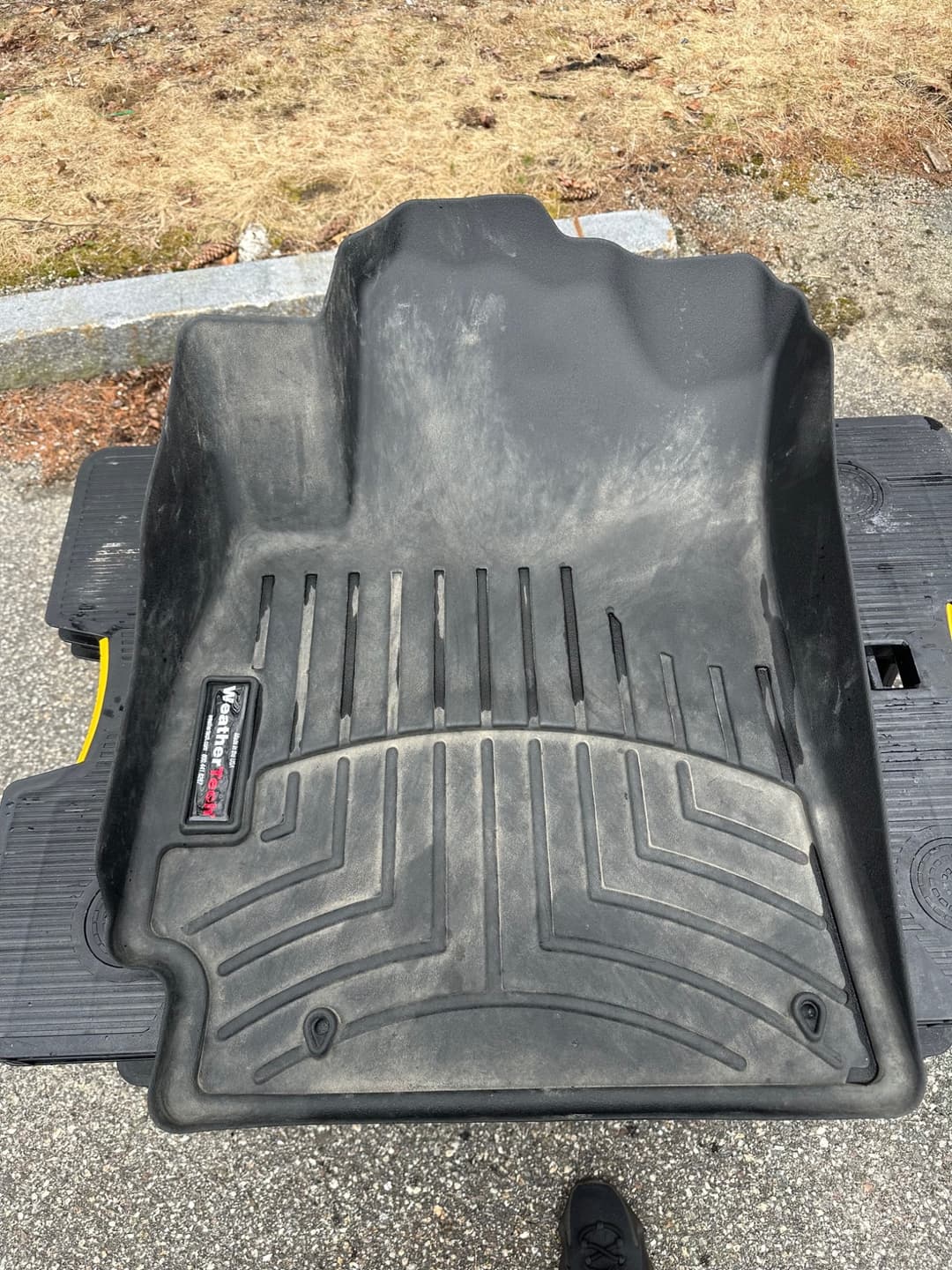 WeatherTech floor mat covered in dirt and salt before deep cleaning.